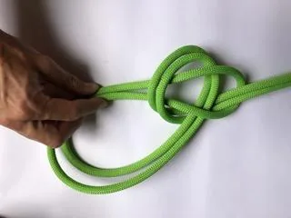 5. Tirer sur les deux boucles ainsi créées pour serrer le nœud de chaise.