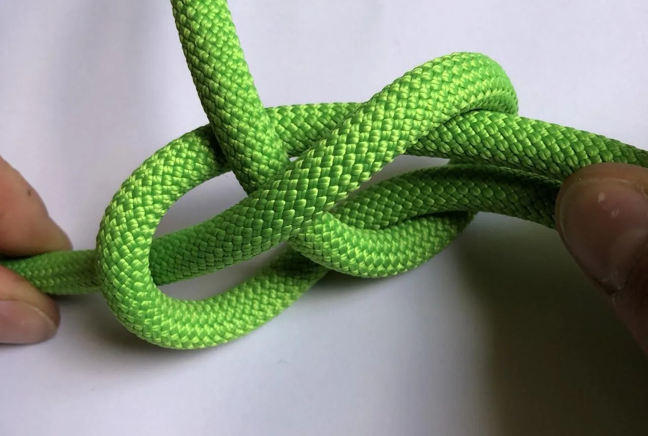 6. Tirer sur le brain qui constitue la boucle et tenir le brin précédemment passé dedans. Ce brin va être “absorbé” par la boucle. Une fois terminé vous pouvez retourner le tout pour voir apparaître le nœud de chaise.